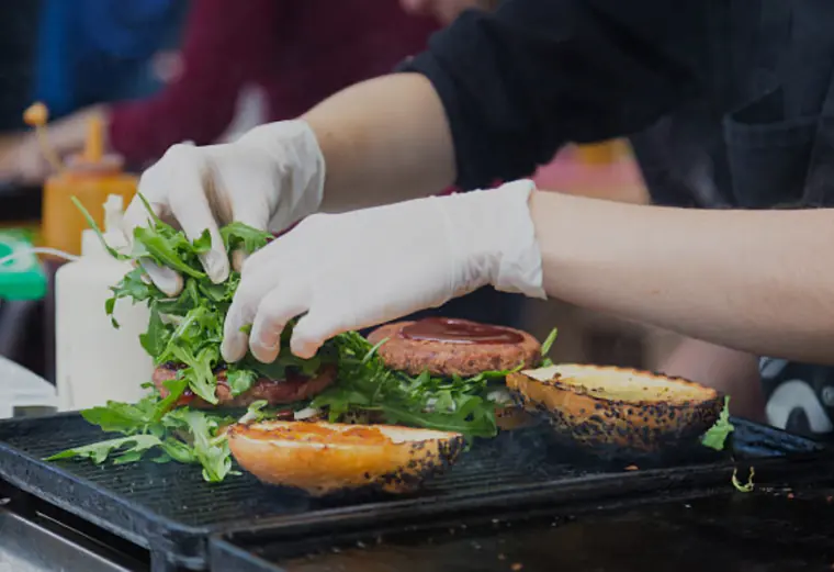 Burger wird auf dem Grill des Foodtrucks belegt